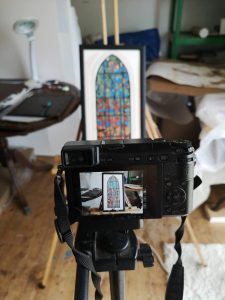 A painting of a stained glass window in camera focus